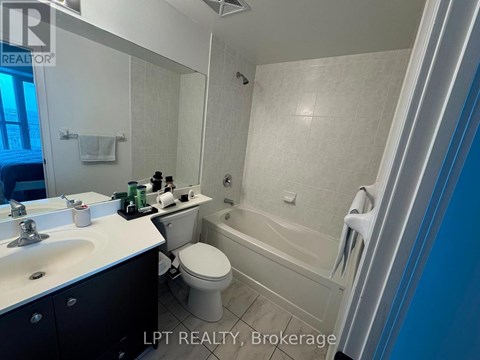 A bathroom with a white toilet, sink, and bathtub.