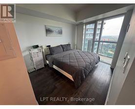 A bedroom with a large bed and a view of the city.