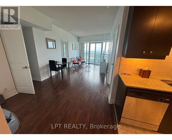 A kitchen with a dining table and chairs in a room with wooden flooring.