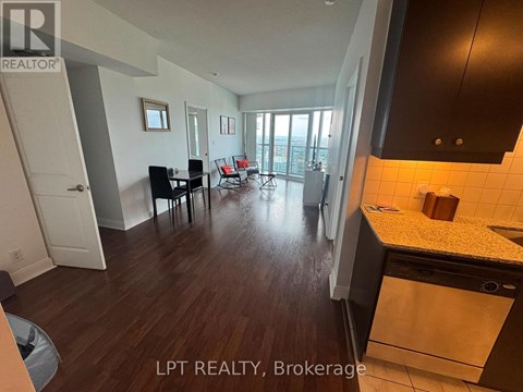 A kitchen with a dining table and chairs in a room with wooden flooring.