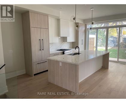 A kitchen with wooden cabinets and a marble countertop.