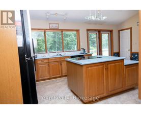 A kitchen with wooden cabinets and a large island.