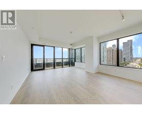 A spacious room with wooden floors and large windows overlooking a cityscape.