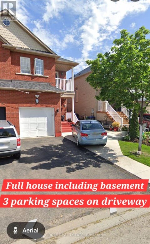 A red brick house with a white garage door and a car parked in front.