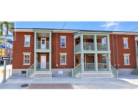 A red brick building with green trim and white railings.