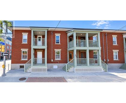 A red brick building with green trim and white railings.