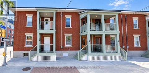 A red brick building with green trim and white railings.