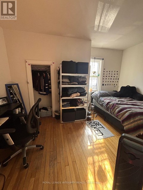A bedroom with a bed, chair, and a window.