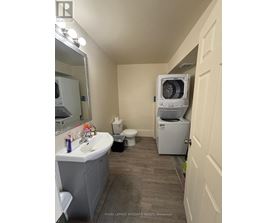 A bathroom with a sink, toilet, and a washing machine.