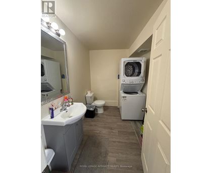 A bathroom with a sink, toilet, and a washing machine.