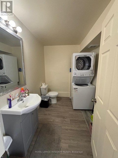 A bathroom with a sink, toilet, and a washing machine.
