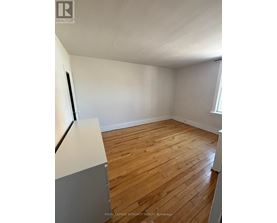 A room with wooden flooring and white walls.