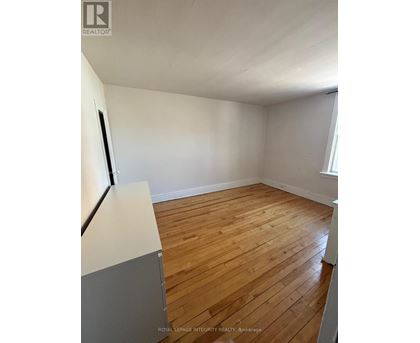 A room with wooden flooring and white walls.
