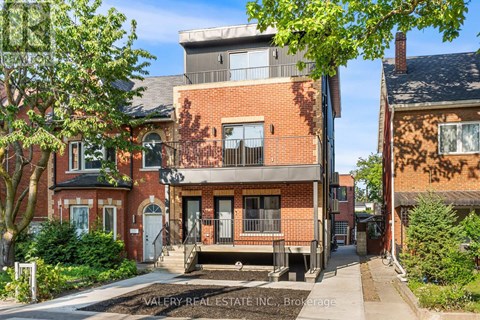 A red brick house with a balcony is for sale.