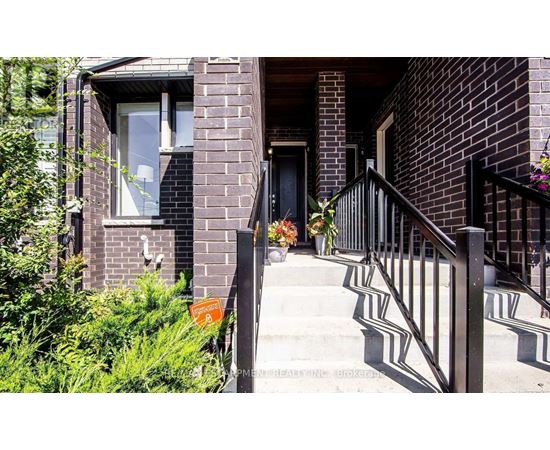 A brick house with a black door and a small porch.