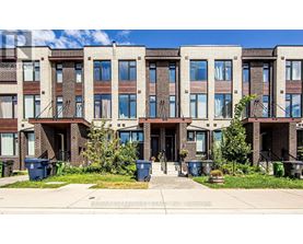 A row of townhouses with blue bins in front.