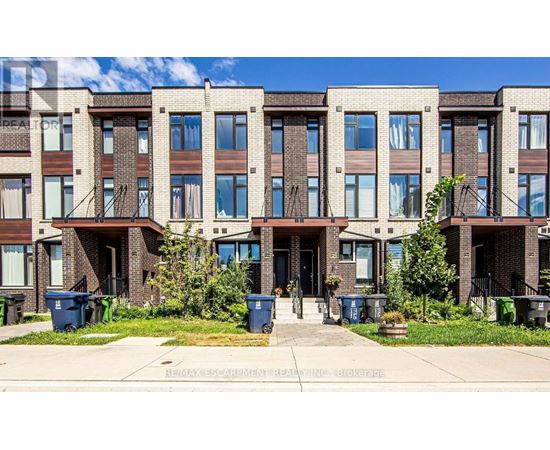 A row of townhouses with blue bins in front.
