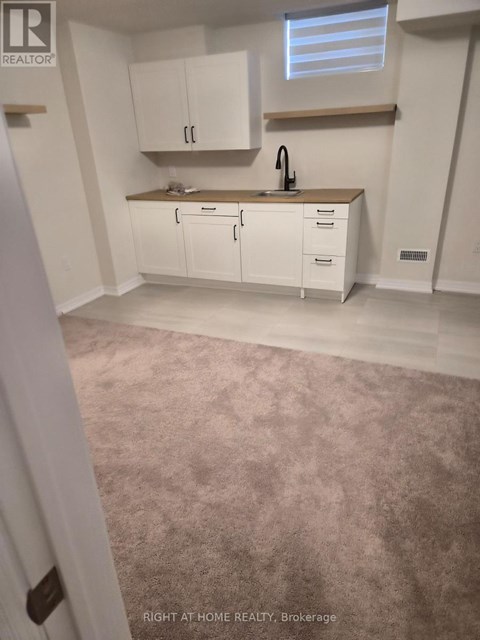 A kitchen with white cabinets and a sink.