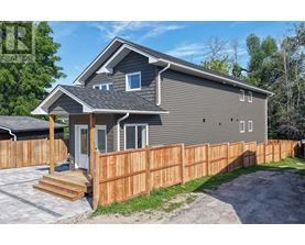 A grey house with a wooden fence and a grey roof.