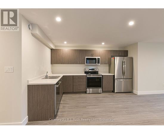 A kitchen with a refrigerator, oven, and microwave.