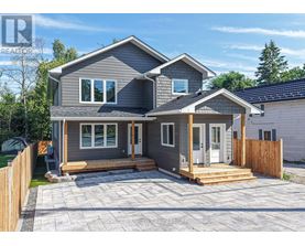 A grey house with a wooden fence and a small porch.