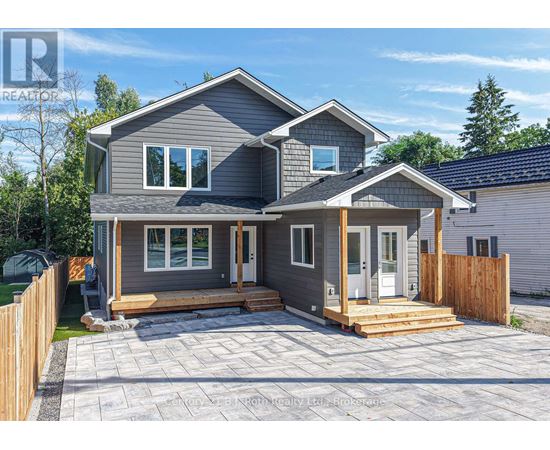 A grey house with a wooden fence and a small porch.