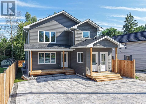 A grey house with a wooden fence and a small porch.