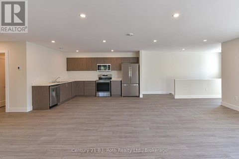 A spacious kitchen with wooden cabinets and stainless steel appliances.