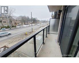 A balcony of a building with a view of a street and cars.