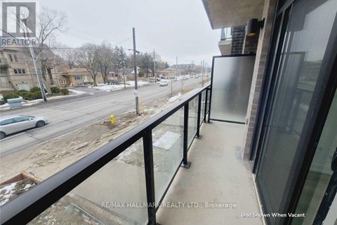 A balcony of a building with a view of a street and cars.