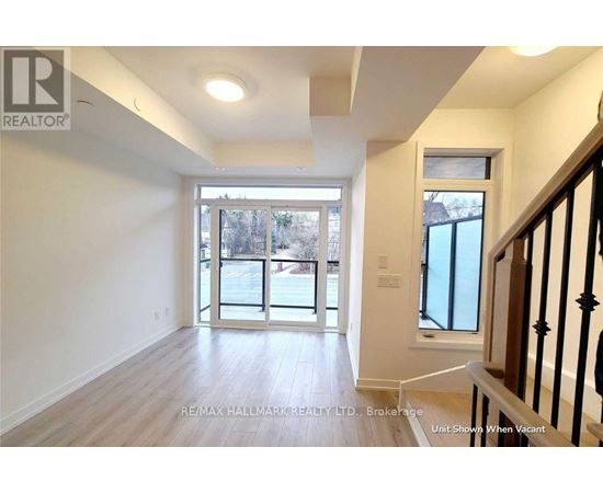 A spacious room with a view of the street through the glass doors.