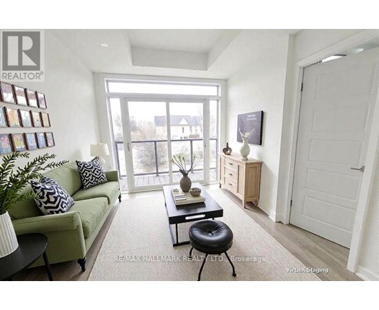 A living room with a green couch, a black coffee table, and a white door.
