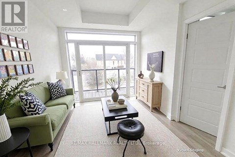 A living room with a green couch, a black coffee table, and a white door.
