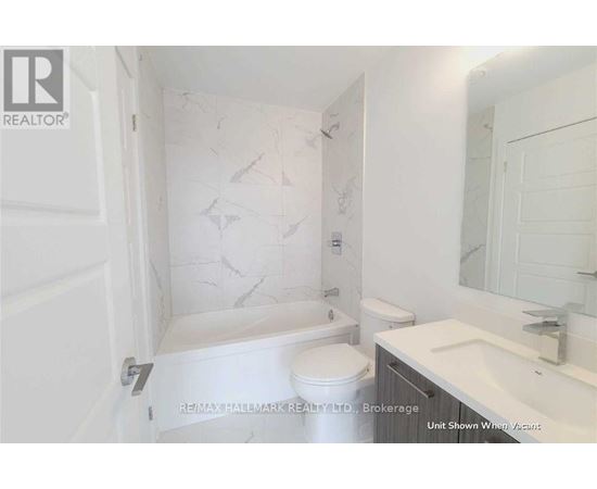 A white bathroom with a marble patterned shower and toilet.