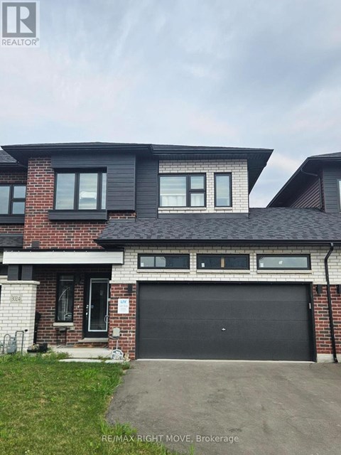 A modern house with a black garage door is for sale.
