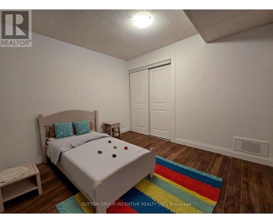 A bedroom with a bed, a bench, and a rug.