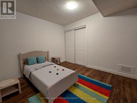 A bedroom with a bed, a bench, and a rug.