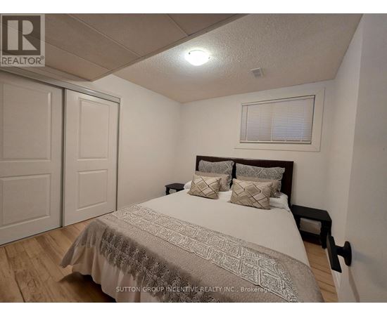 A bedroom with a bed, pillows, and a window with blinds.