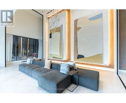 A modern living room with a large grey sofa and a large abstract painting on the wall.