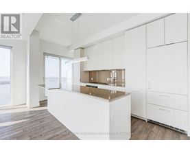 A modern kitchen with white cabinets and a wooden island.