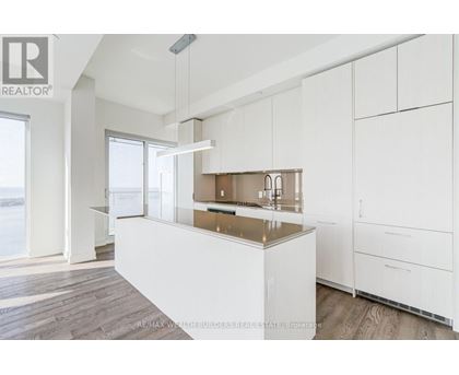 A modern kitchen with white cabinets and a wooden island.