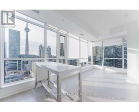 A spacious room with a large table and a view of the city skyline through the windows.