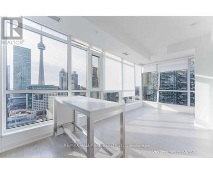 A spacious room with a large table and a view of the city skyline through the windows.