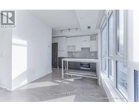 A white kitchen with a table and chairs in the middle of the room.