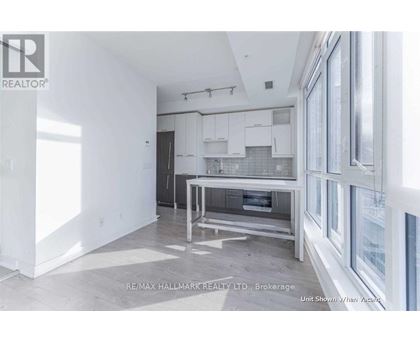 A white kitchen with a table and chairs in the middle of the room.