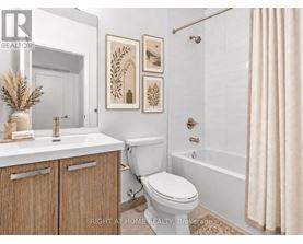 A bathroom with a toilet, sink, and a shower.