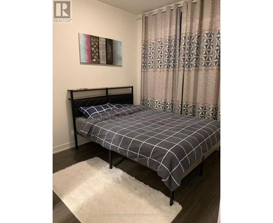 A bedroom with a bed and a painting on the wall.