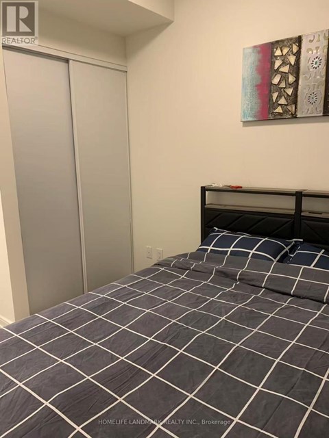 A bedroom with a bed and a painting on the wall.