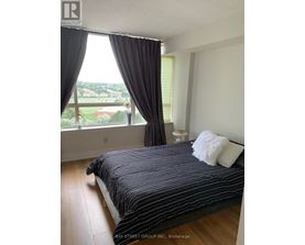 A bedroom with a large bed and a view of the city.