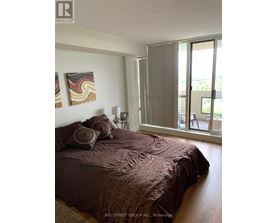 A bedroom with a large bed and a painting on the wall.